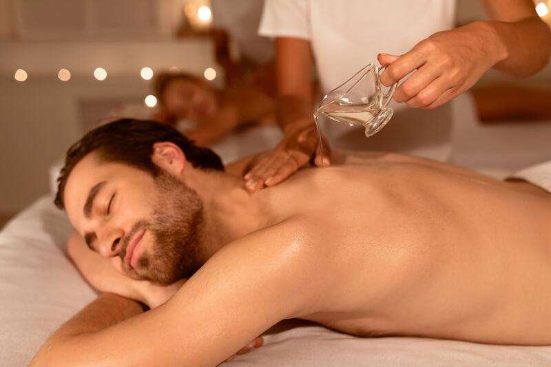 masseur-pouring-oil-couples-massage-therapy-spa-masseur-pouring-oil